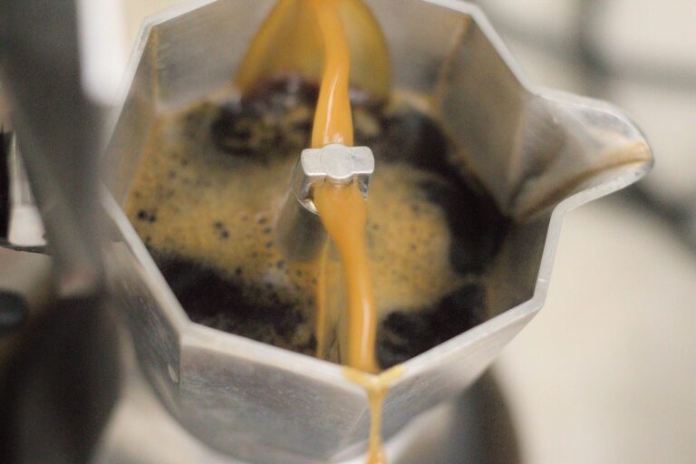 Frischer Kaffee strömt aus dem Steigrohr eines geöffneten Espressokochers