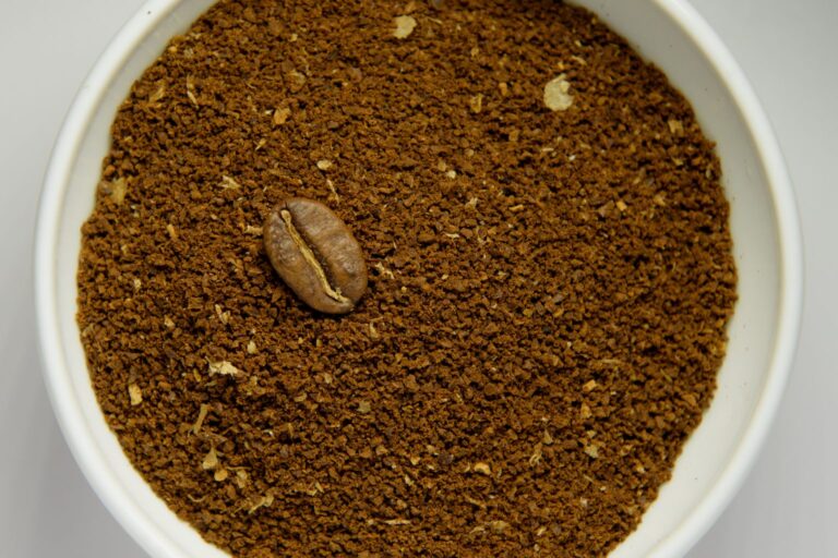 Mittelfein gemahlener Kaffee in einer weißen Schale mit einer ganzen Kaffeebohne