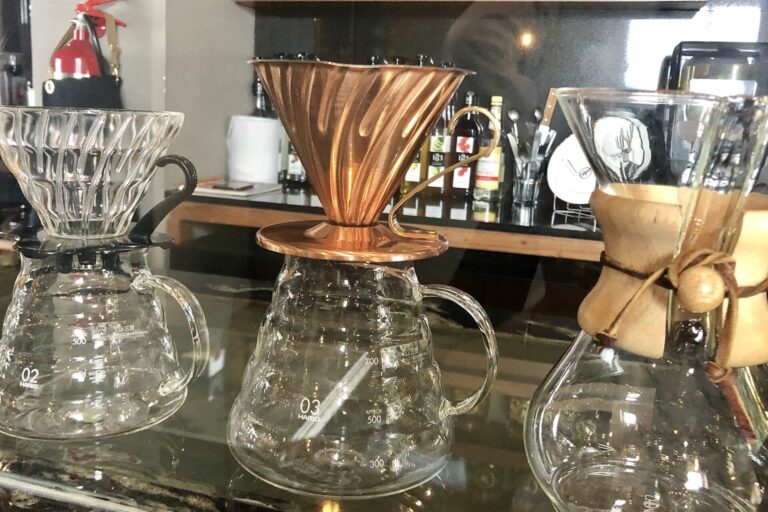 Verschiedene Handfilter und eine Chemex nebeneinander auf einer Theke